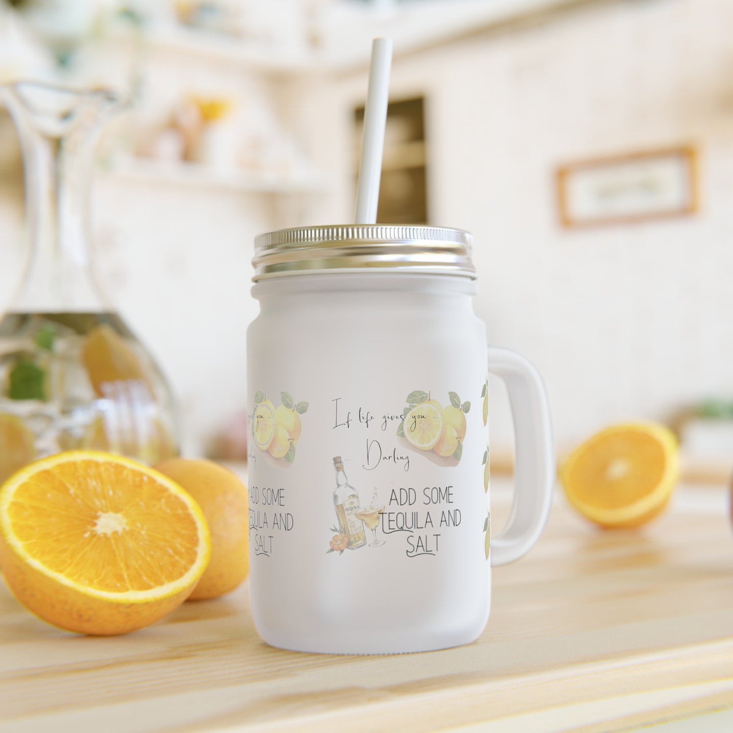 Mason jar mug with lemon design and text on a wooden surface with citrus fruits lying next to the mug.